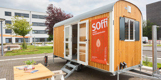 Container vor dem ein Tisch steht. Das mobile Nachhaltigkeitsbüro
