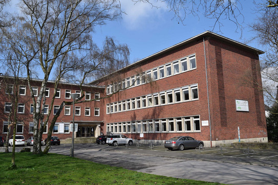 Hohe Str. 141 Dreistöckiges Backsteingebäude mit Bäumen und Grün im Vordergrund
